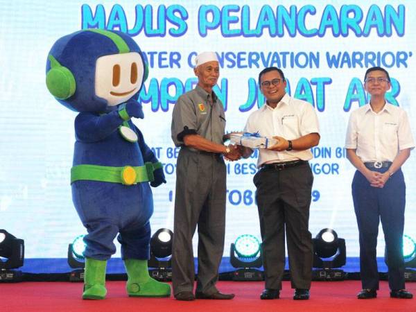Amirudin (tengah) menyerahkan bidal kepada wakil penduduk sambil diperhatikan oleh Suhaimi pada Majlis Pelancaran ‘Be A Water Conversation Warrior’ Kempen Jimat Air Selasa lalu. Foto: ROSLI TALIB
