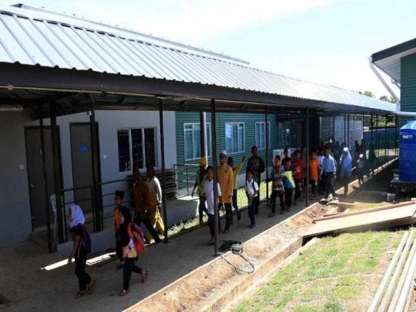 Murid-murid Sekolah Kebangsaan (SK) Pulau Balambangan melintasi bangunan dewan makan Asrama Harian Luar Bandar di sekolah itu yang siap sepenuhnya bulan lepas dan sedia untuk mereka tinggal. - Foto Bernama