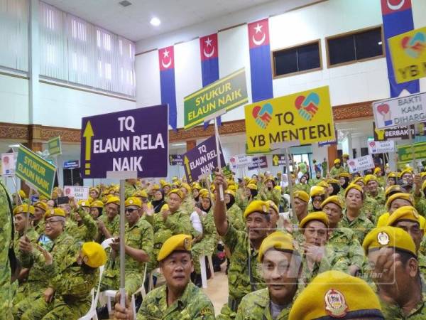 Anggota Rela mengangkat sepanduk tanda penghargaan di atas kenaikan elaun pada majlis Rela Bersama Pemimpin di Dewan Jubli Intan Sultan Ibrahim Pontian, di sini hari ini.