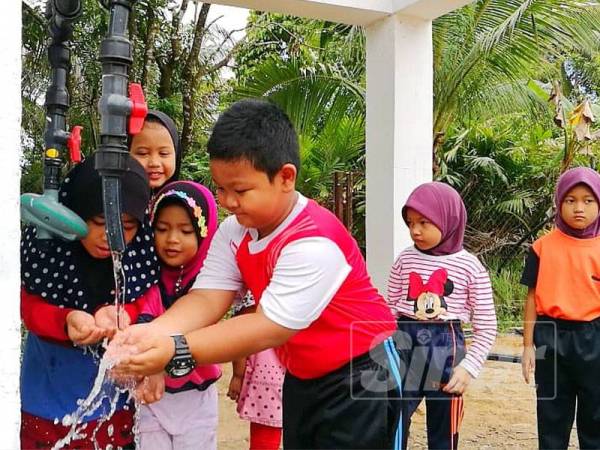 Kanak-kanak di Kampung Padang Bukit, Lubok Setol tidak melepaskan peluang menikmati air mineral semula jadi yang ditandak dari Bukit Kwong.