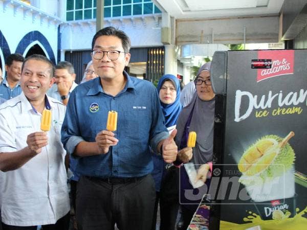 Tze Tzin (kanan) mencuba ais krim durian pada sesi dialog bersama pemain industri durian hari ini.