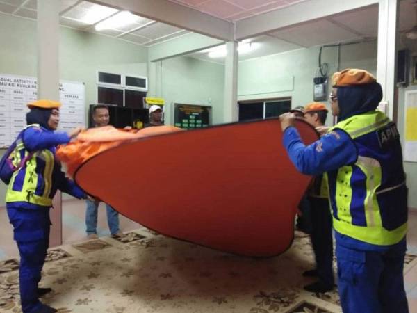 Anggota APM membantu menyiapkan khemah untuk kegunaan mangsa yang dipindahkan ke PPS di surau Kampung Kuala Repas malam tadi. - Foto APM