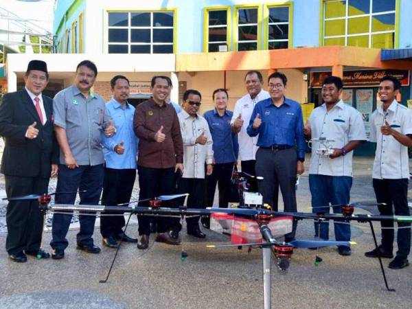 Tse Tzin (tiga dari kanan) ditemani Abdul Yunus (empat dari kiri) melihat dron agrikultur yang mampu menyembur baja seluas 20 hektar ladang pada satu-satu masa.