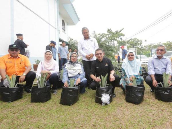 Salahuddin (tengah) dan isteri, Datin Seri Fatimah Taha (tiga dari kanan) bersama Ketua Pengarah Lembaga Perindustrian Nanas Malaysia (LPNM), Ruhaida Mashhor (tiga dari kiri) serta Pengerusi LPNM, Datuk Abdul Malik Abul Kassim (dua dari kanan) menanam nanas sebagai gimik pelancaran program kebitaraan nanas di pekarangan Masjid Dato’ Mohd Noh Gadot semalam.