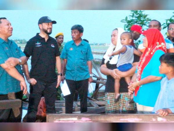Mukhriz ( dua dari kiri) menziarahi Nurul Farhana ( empat dari kiri) yang menjadi mangsa ribut di Kampung Pida 4 Deli, Mukim Jeram, di sini petang tadi