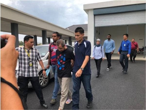 Dzulkafli (tengah) turut sama didakwa atas tuduhan ATIPSOM 2007 di mahkamah sama.