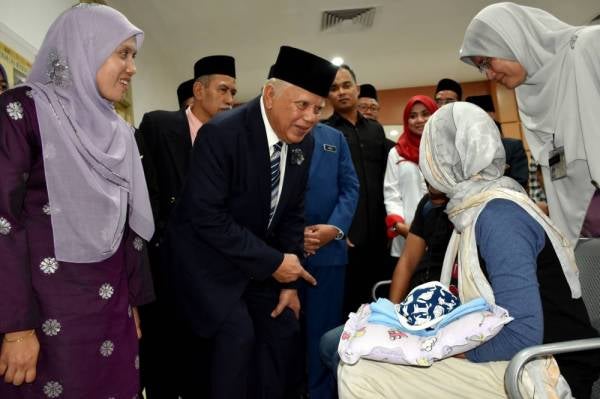 Mohd Khalil (dua dari kiri) beramah mesra bersama orang ramai yang mendapatkan rawatan di Klinik Kesihatan Rembia selepas merasmikan klinik berkenaan hari ini. -Foto Bernama