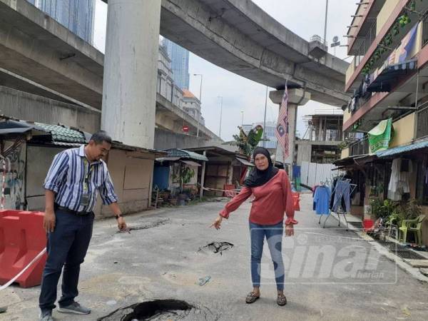 Penduduk menunjukkan keadaan jalan yang mendap di Flat PKNS Jalan Tun Razak semalam.