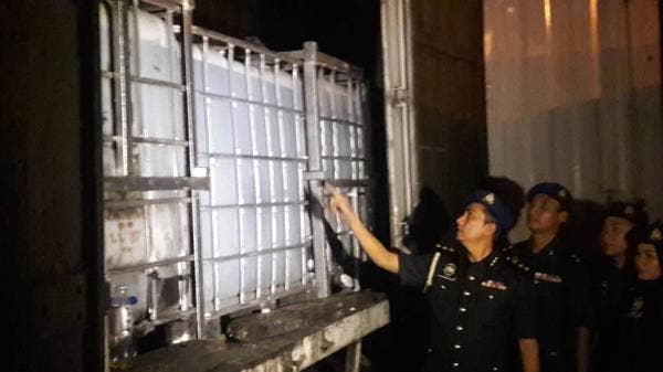 Mohd Suffian bersama pegawainya memeriksa minyak masak yang ditemui hasil serbuan ke atas sebuah premis haram, di sini semalam