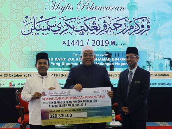 Yang Dipertua Dewan Undangan Negeri (DUN) Negeri Sembilan Datuk Zulkefly Mohamad Omar (tengah) menerima replika cek daripada Timbalan Ketua Pengarah (Operasi) Jabatan Kemajuan Islam Malaysia (JAKIM) Datuk Paimuzi Yahya (kiri) pada majlis pelancaran Program Rahmah peringkat negeri di Sendayan, hari ini. - Foto Bernama