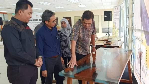  Ibrahim (kanan) melihat meja yang siap direka oleh kakitangan Kraftangan menggunakan produk campuran bahan resin dan kayu ketika melawat makmal itu hari ini.
