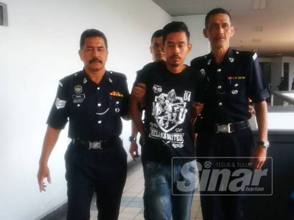 Shahrul Nizam diiringi anggota polis selepas keluar dari Mahkamah Majistret Ayer keroh, di sini, hari ini.