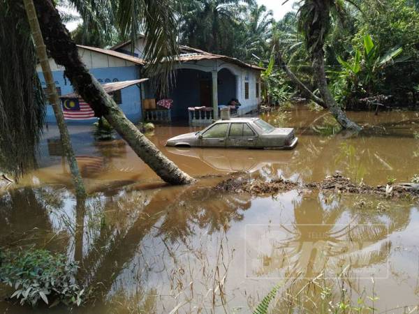 Keadaan salah sebuah rumah di Kampung Melayu Bukit Panjang yang masih digenangi air banjir.