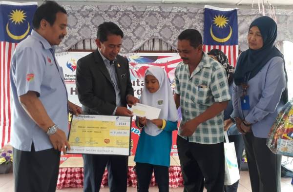 Nurul Huda (tengah) menerima cek dari Zamri. Turut kelihatan Shaharuddin (kiri) dan Amran (dua dari kanan).