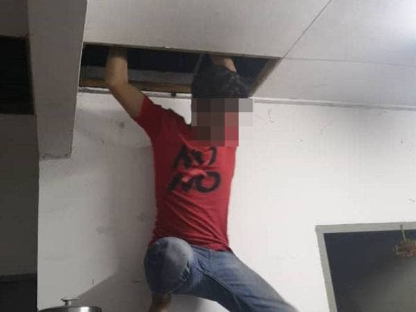 Antara Pati yang cuba meloloskan diri melalui siling rumah sewaktu serbuan oleh pihak JIM di sebuah kawasan pangsapuri sekitar Klang. - Foto Imigresen