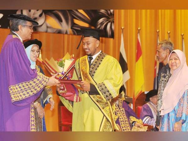 Rosely (kiri) menyampaikan anugerah Graduan Keseluruhan Terbaik kepada Muhammad Aqil Aqmar yang diiringi ibu bapanya ketika Majlis Konvokesyen UCAM ke-18 di Serdang semalam. - Foto ROSLI TALIB