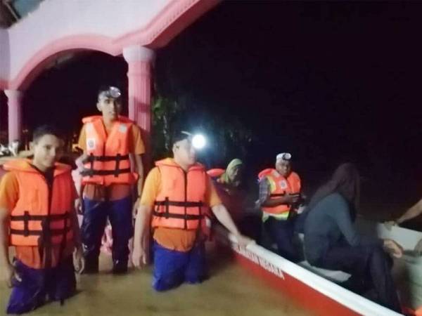 Sekumpulan anggota APM Baling membantu memindahkan mangsa banjir.