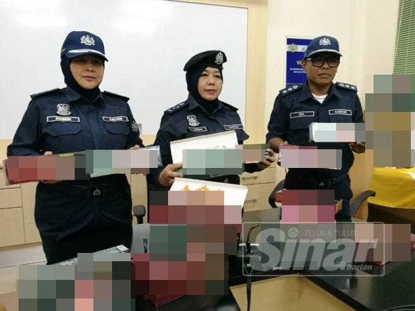 Azimah (kanan) dan Maimon menunjukkan sebahagian rokok seludup yang dirampas
