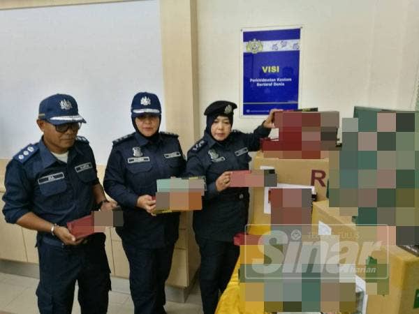 Azimah (tengah) dan Maimon menunjukkan sebahagian rokok seludup yang dirampas pada sidang medianya di sini, hari ini