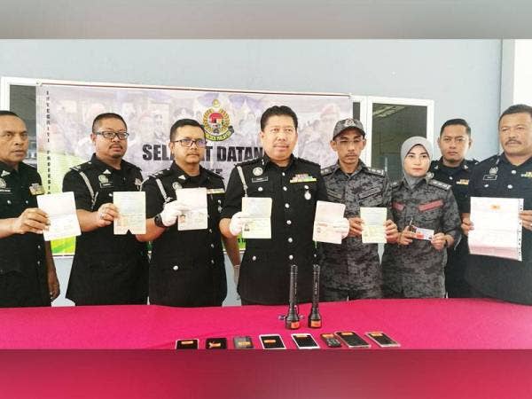 Basri (empat dari kiri) menunjukkan dokumen palsu.