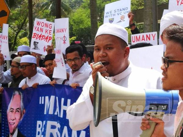 Muhammad Ikhwan mengetuai Himpunan Menyokong Naib Canselor UM di luar pekarangan pintu utama UM sebelum ditahan.