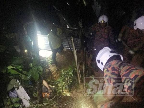 Anggota bomba menjalankan operasi mengesan mangsa dipercayai tertimbus dalam kejadian tanah runtuh.