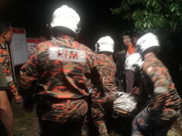 Anggota bomba ketika mengusung mayat mangsa selepas mengeluarkannya dari kumbahan berkenaan.