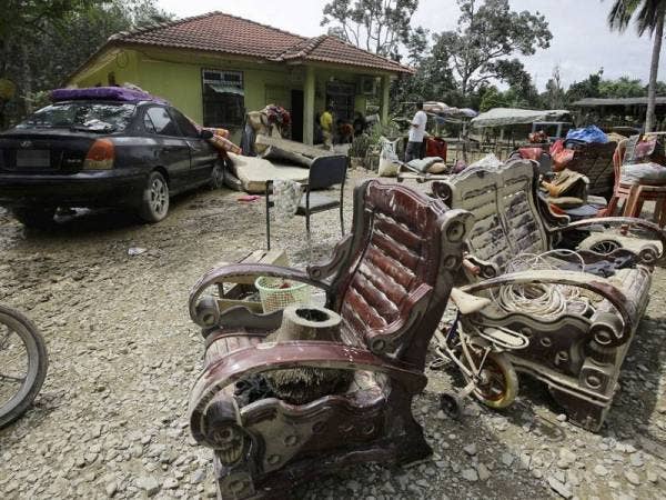 Sebahagian perabot di sebuah rumah yang diselaputi lumpur ekoran banjir yang melanda di beberapa kawasan Simpang Durian semalam. - Foto Bernama