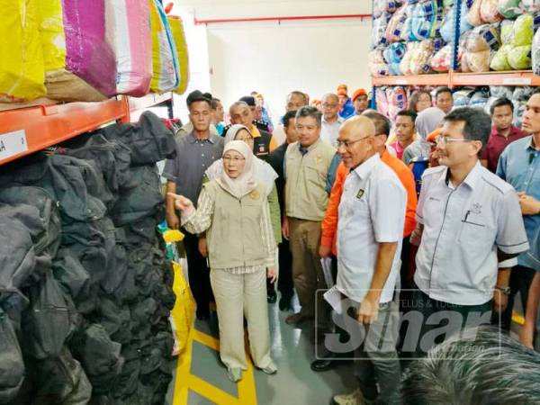 Wan Azizah meninjau keperluan yang disediakan untuk mangsa banjir di Depoh Simpanan Keperluan Bencana, Kompleks Penyayang JKM dekat sini hari ini.