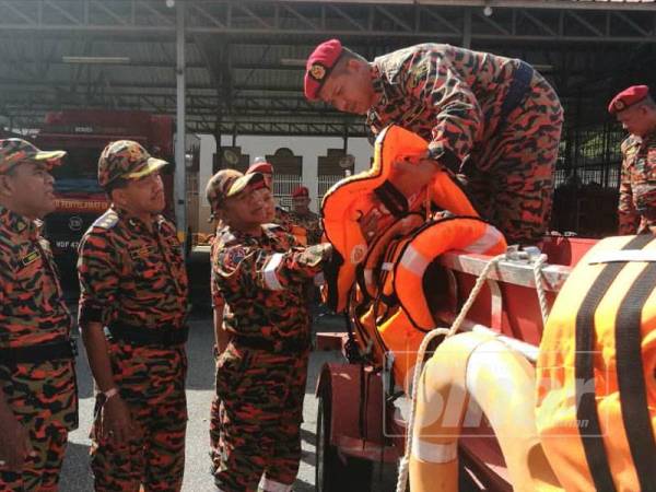 Mohamad Shoki (dua dari kanan) sedang memeriksa keadaan jaket keselamatan bagi memastikan ianya dalam keadaan selamat untuk digunakan semasa bantuan banjir nanti. Hadir sama, Timbalannya, Penguasa Kanan Bomba 1 Sharikan Bustaman (kiri) dan Ketua Cawangan Pengurusan Pasukan Penyelamat JBPM Malaysia, Penolong Pesuruhjaya Bomba Mohd Zahar Abdullah.