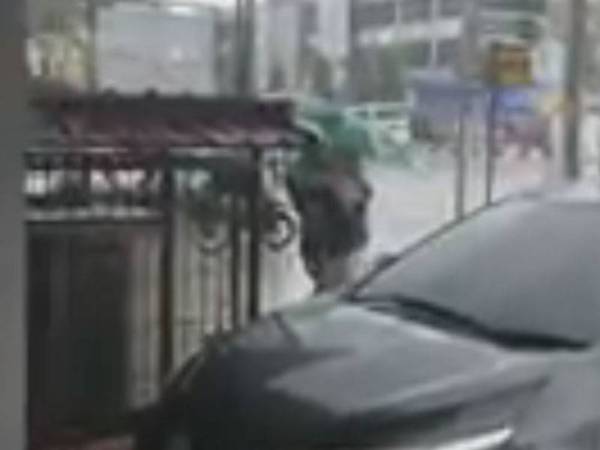 Wanita dan seorang lelaki yang mengangkat pak cik itu ke tempat berbumbung untuk dirinya dapat berlindung daripada hujan.