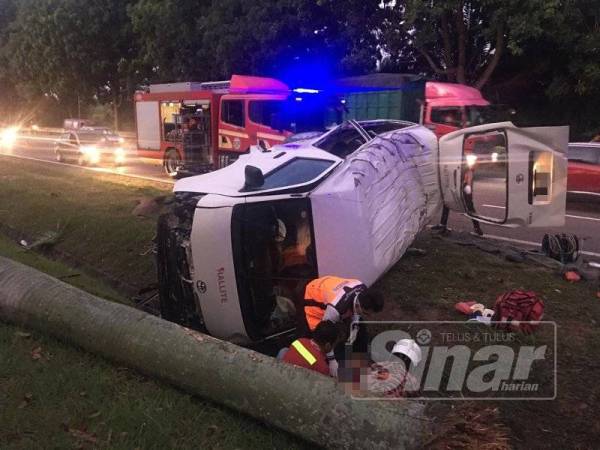 Anggota penyelamat membantu mengeluarkan mangsa yang tersepit dalam van terbabit.