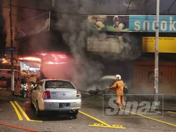 Pasukan bomba berusaha memadamkan kebakaran bengkel motosikal di Jalan Tenaga awal pagi tadi.