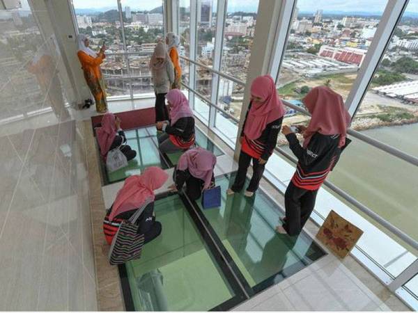 Pengunjung tidak melepaskan peluang merasai pengalaman berada di atas lantai kaca setinggi 16 tingkat di galeri 'sky bridge' Jambatan Angkat (Drawbridge) ketika ditemui baru-baru ini. - Foto Bernama
