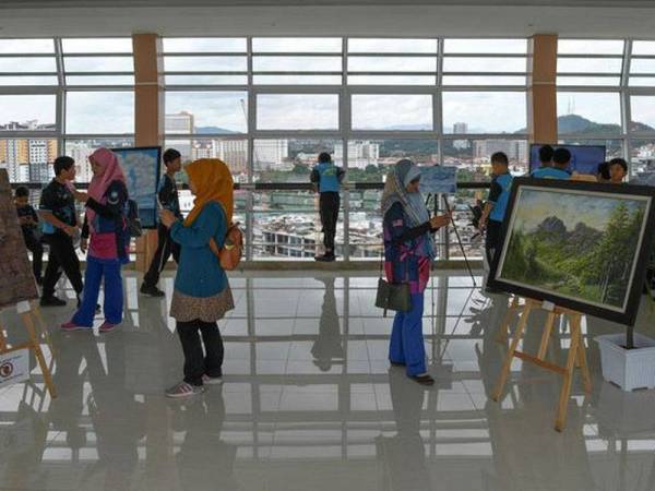 Pengunjung menyaksikan pelbagai lukisan dihasilkan oleh pelukis tempatan yang dipamerkan di galeri 'sky bridge' Jambatan Angkat (Drawbridge) baru-baru ini. - Foto Bernama