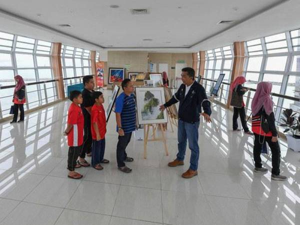  Ketua Pegawai Eksekutif TI Properties Sdn Bhd, Khalizan Mahmud (kanan) memberi penerangan kepada pengunjung ketika meninjau kehadiran pengunjung di galeri 'sky bridge' Jambatan Angkat (Drawbridge) baru-baru ini. - Foto Bernama