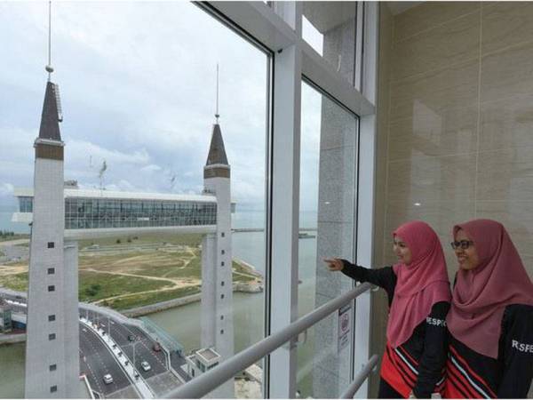 Pengunjung Nur Adilah Ahmad Zaki, 22, (kiri) bersama rakannya menikmati pemandangan dari atas galeri 'sky bridge' Jambatan Angkat ketika ditemui baru-baru ini. - Foto Bernama