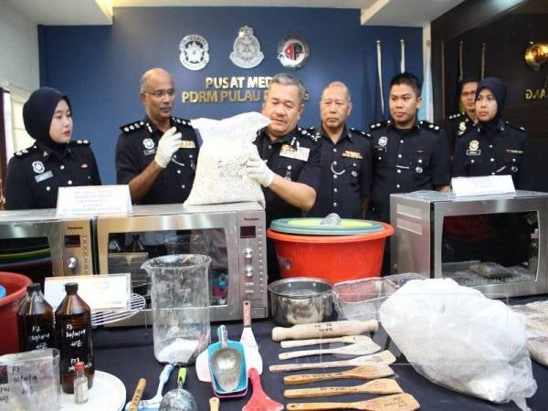 Roslee (tengah) menunjukkan dadah dan peralatan memproses dadah yang dirampas.