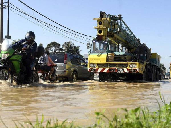 Pemandu kenderaan dan penunggang motosikal perlu berhati-hati kerana terpaksa mengharungi air berikutan banjir kilat di Hulu Langat hari ini. - Foto Bernama