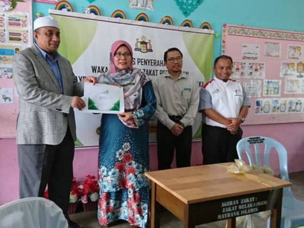 Guru SRA JAIM menerima dokumen wakalah daripada Maybank Islamik Berhad bagi peruntukan kerusi dan meja sekolah.