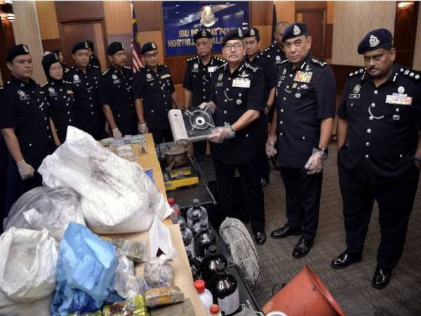 Mazlan bersama sebahagian para pegawainya menunjukkan peralatan memproses dadah yang dirampas pada Sidang Media Kejayaan Menumpaskan Sindiket Dadah dan Pembongkaran Makmal Dadah Haram di Ibu Pejabat Polis Kuala Lumpur hari ini. - Foto: Bernama