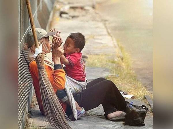 Gambar terakhir yang dikongsi netizen Lina sedang bermain dengan anaknya selepas selesai melakukan kerjanya sebagai tukang sapu.