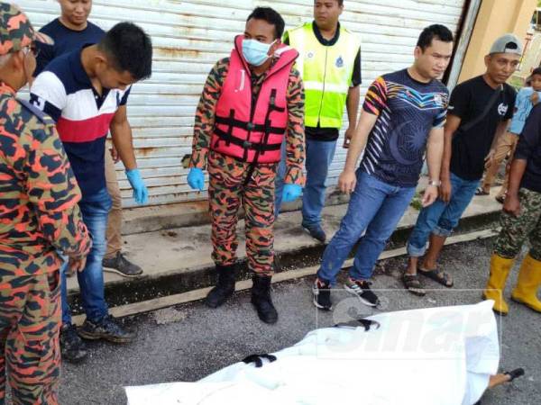 Mayat mangsa dibawa keluar dengan bantuan anggota bomba dari Balai Bomba dan Penyelamat Seri Iskandar sebelum diserahkan kepada polis.
