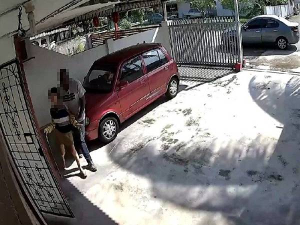 Salah seorang suspek memaksa mangsa masuk ke dalam rumah.