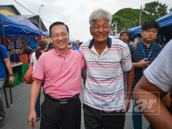 Jeck Seng bersama salah seorang pengunjung Pasar Pagi Pekan Nanas hari ini. - Foto SHARIFUDIN ABDUL RAHIM