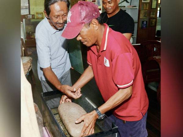 Abdullah (tengah) menunjukkan batu terapung kepada pengunjung muzium yang merupakan antara 300 koleksi barangan tulen berusia ratusan tahun. - Foto Bernama