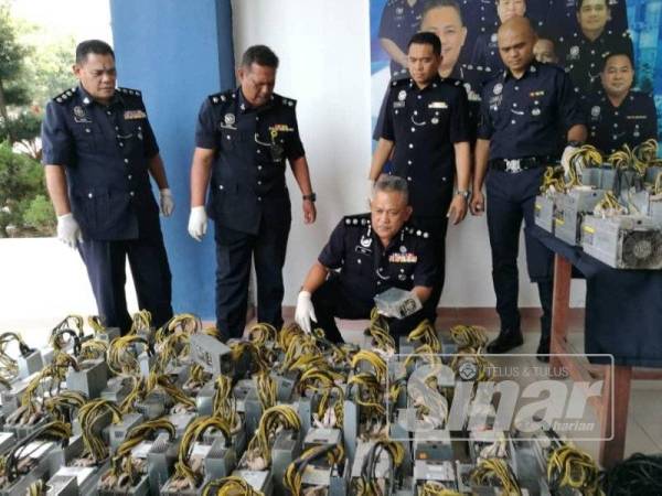 Mohd Said (duduk) melihat mesin perlombongan bitcoin yang dirampas pada sidang akhbar di IPD Seremban hari ini.