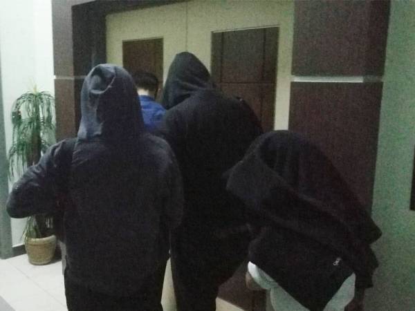 Tertuduh menutup muka ketika dibawa keluar dari mahkamah.