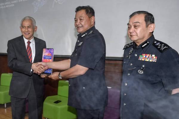 Abdul Hamid menyampaikan plak penghargaan kepada Ir Abdul Rahim pada Majlis Perasmian Penutup Persidangan Kebangsaan Jenayah Komersil bertemakan 'Ancaman dan Pendekatan Teknologi Siber 2019' di Universiti Malaya hari ini. - Foto Bernama