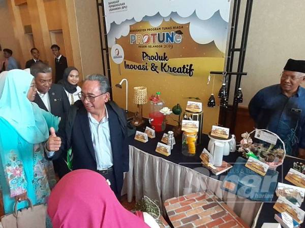 Mohd Azizi menunjukkan tanda bagus ketika melihat hasil jualan usahawan semalam.